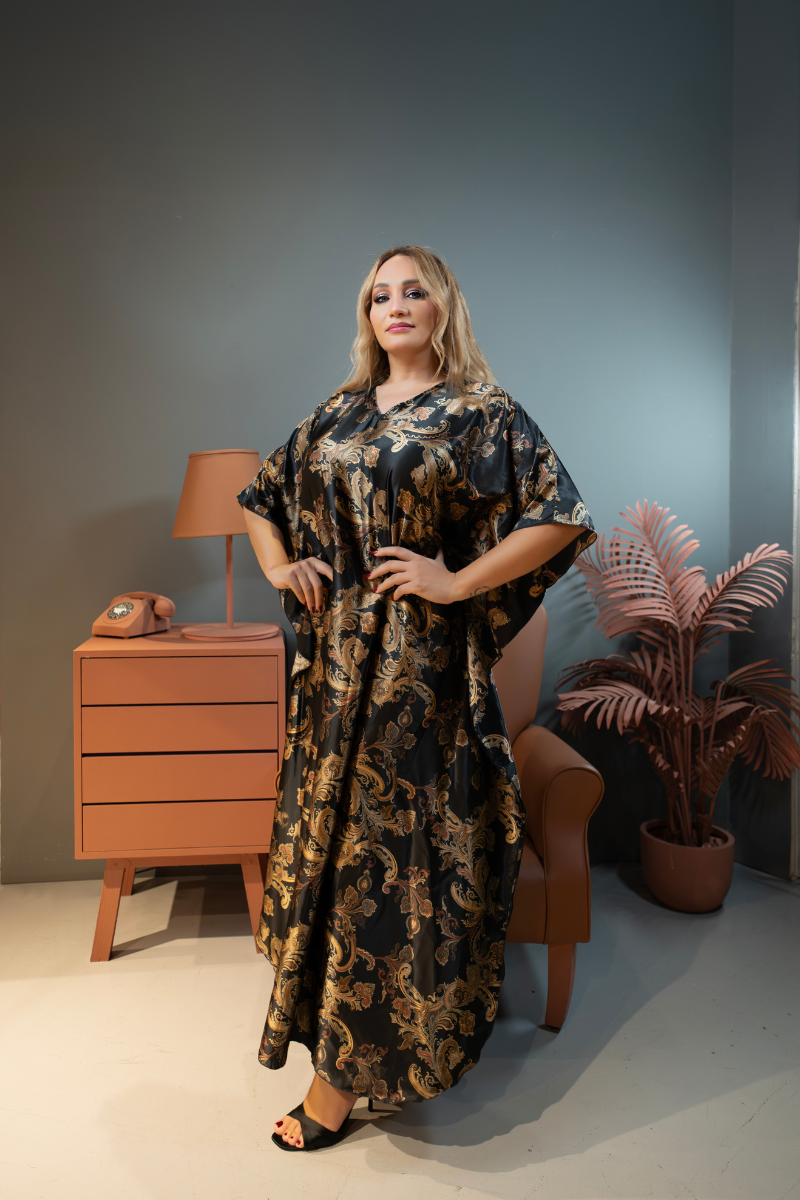 Woman in a floral dress standing in a room with a lamp, phone, and plant.
