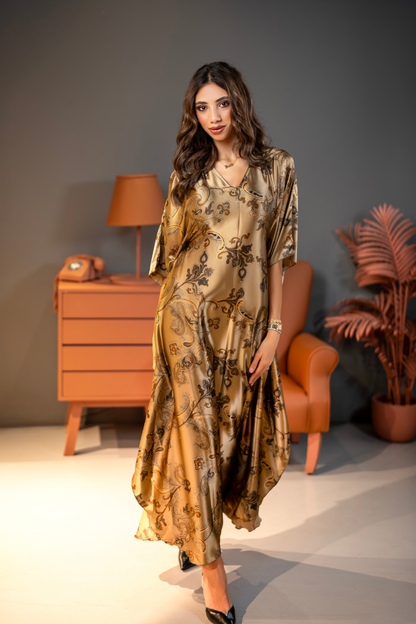 Woman in a floral dress standing in a room with a lamp and plant.