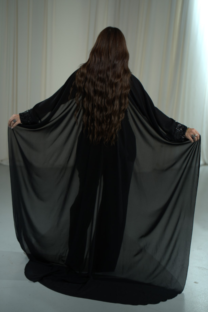 Person holding a black fabric in front of a white curtain